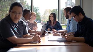 Students sitting around a table studying and talking.